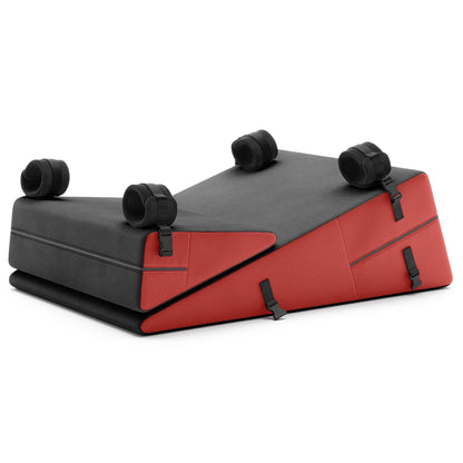 A set of dogwood red ultraleather Bondage ramp and wedge, Bedroom Furniture by Liberator with handcuffs on a white background.