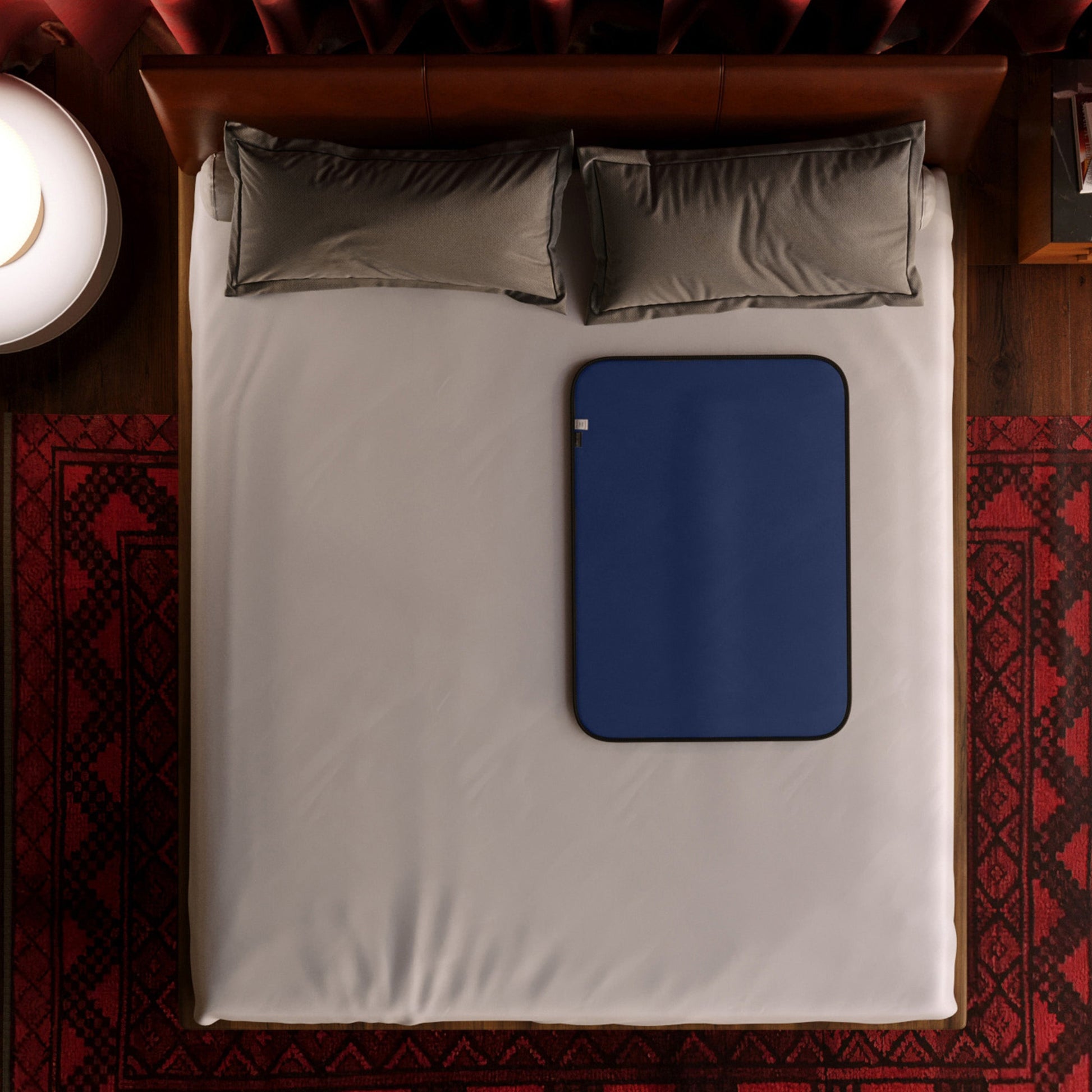 A mini blue Fascinator Splashproof Throws, Bedroom Furniture by Liberator sitting on a bed.