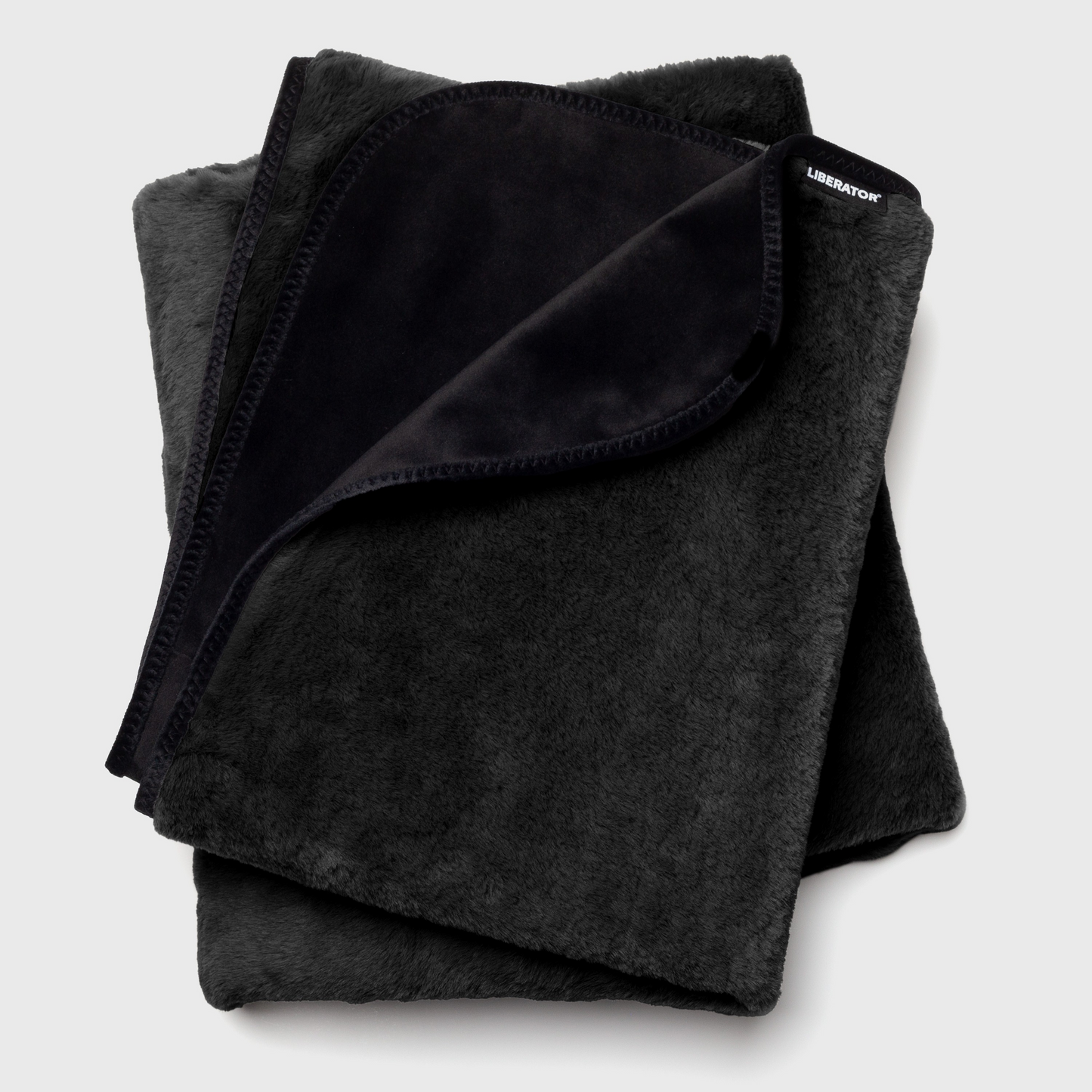 A black faux fur Fascinator Splashproof Throws, Bedroom Furniture by Liberator against a white background.