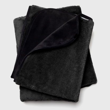 A black faux fur Fascinator Splashproof Throws, Bedroom Furniture by Liberator against a white background.
